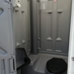 Enkelt toilet med urinal, toilet, håndsprit og toiletpapir